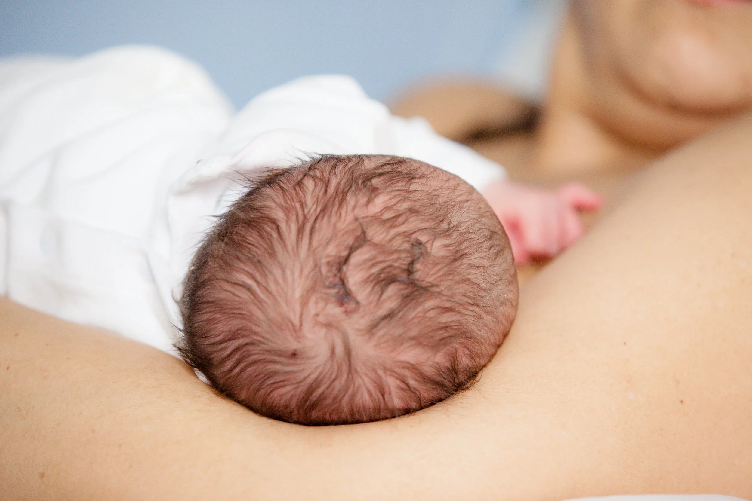 Ritratto di maternità nei primissimi giorni in ospedale alla Mangiagalli di Milano, con neonato appoggiato sul corpo della mamma.