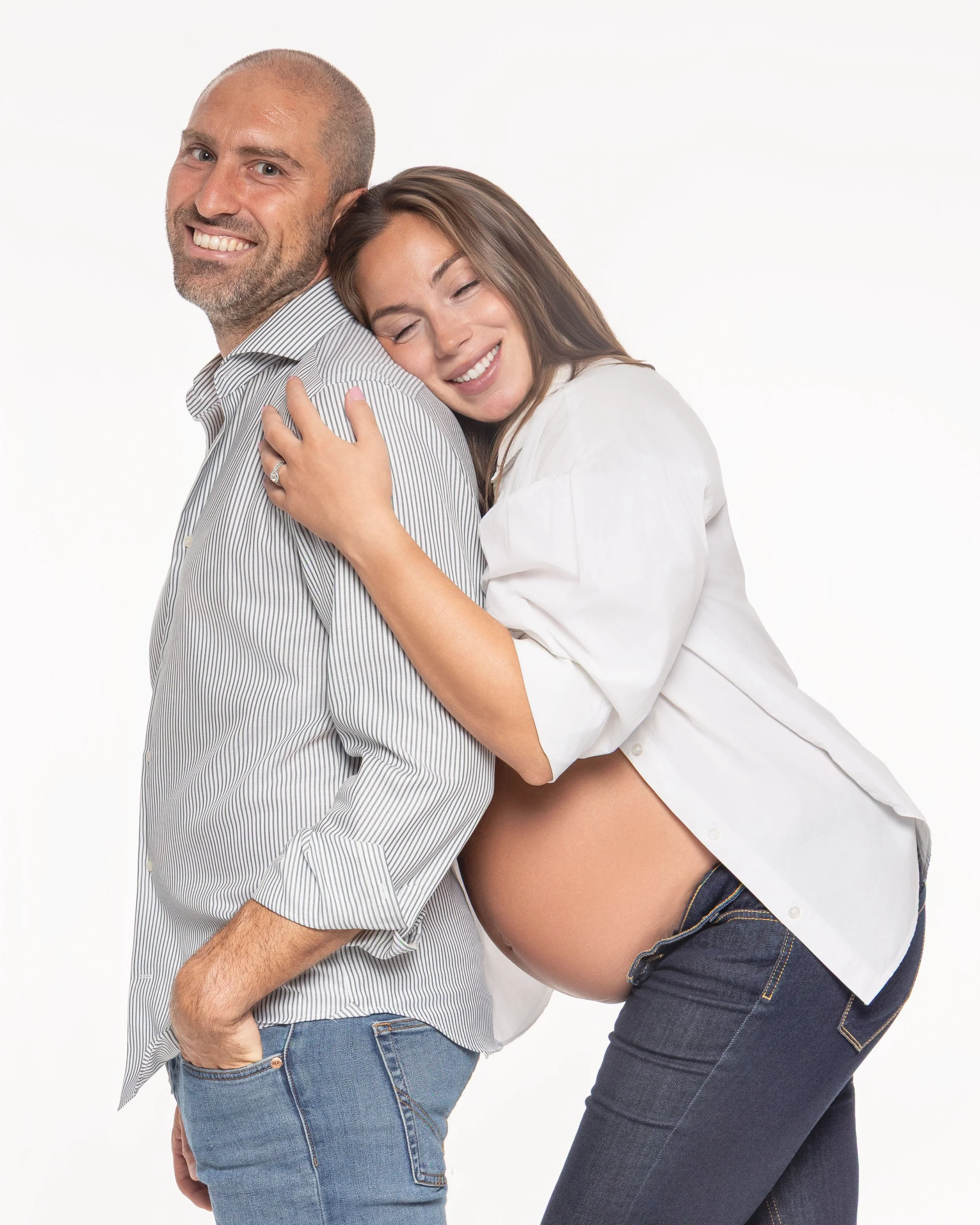 Ritratto fotografico di gravidanza in studio a Milano, con coppia guidata in un gesto naturale e affettuoso durante la sessione.