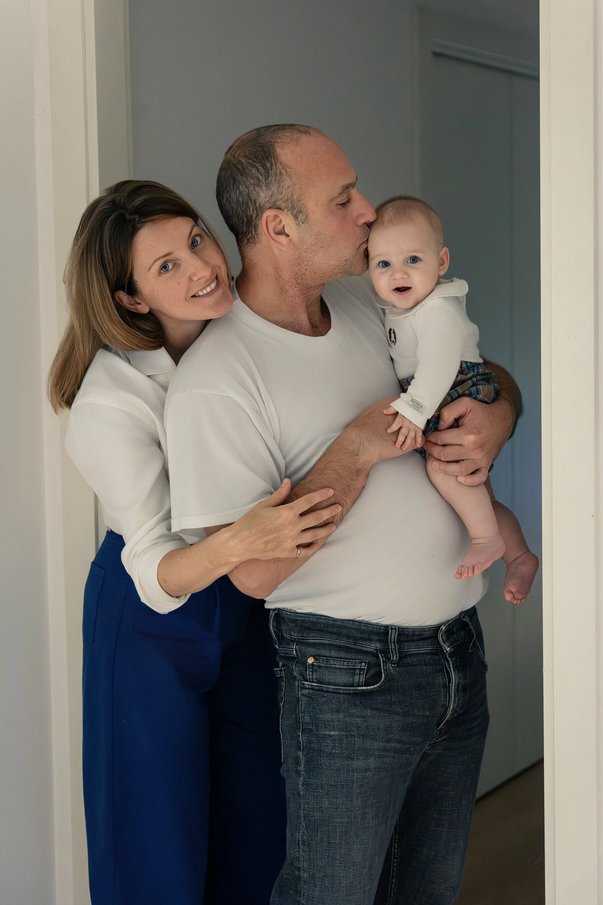 Genitori con il loro bambino vestiti con colori coordinati durante un servizio fotografico di famiglia a domicilio a Milano.