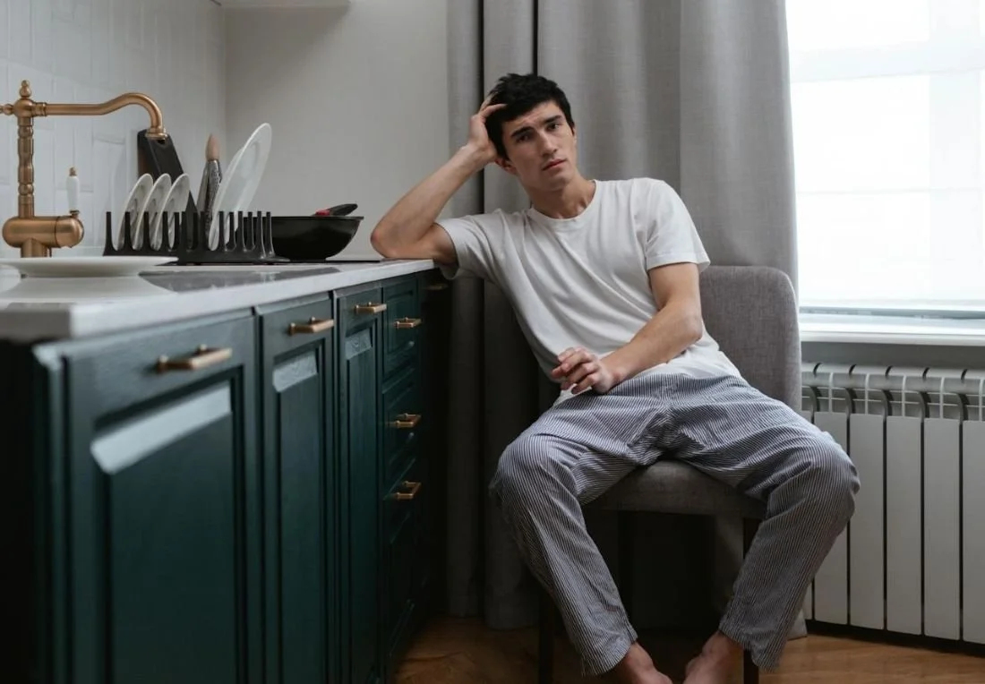 A Bored Man Leaning on the Kitchen Counter