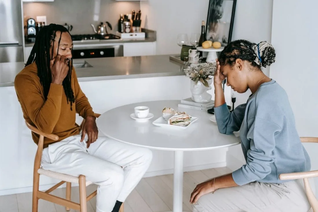 A couple arguing at kitchen table