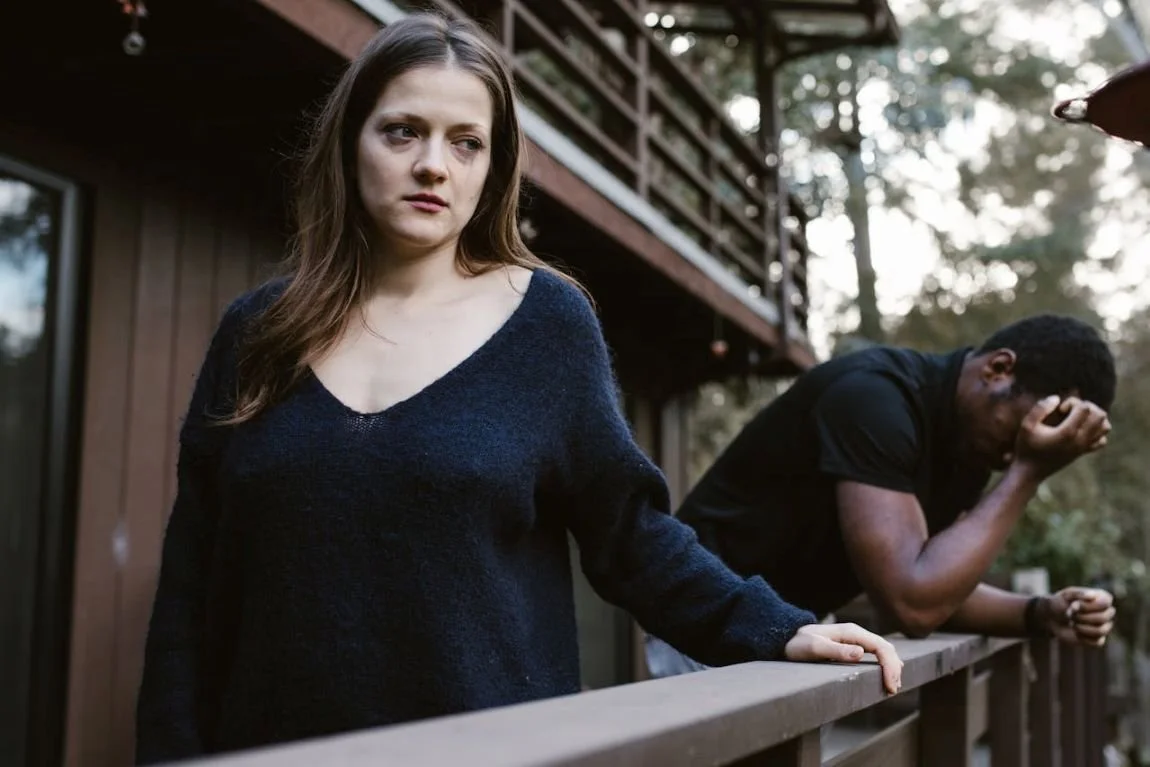 a woman and man on balcony looking in different directions