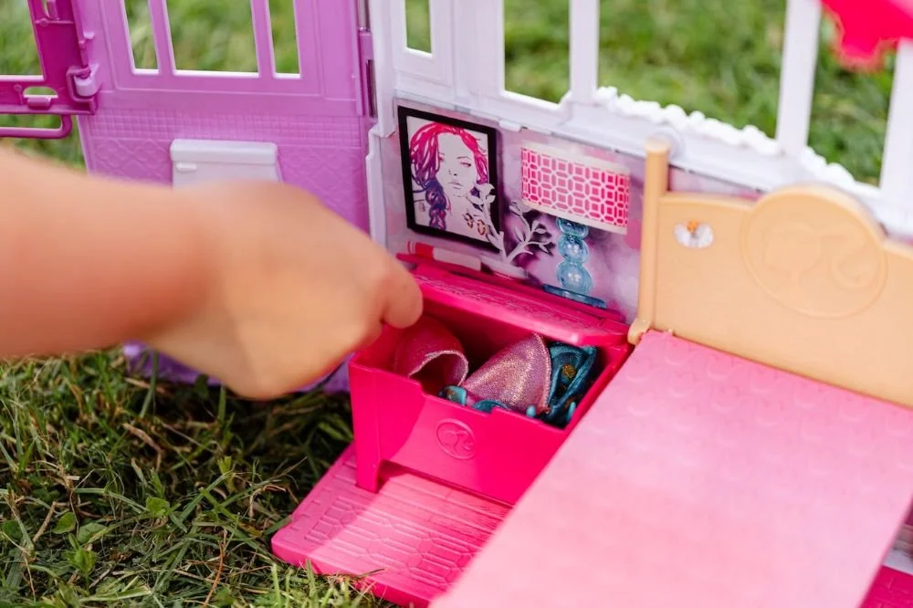 Child’s hand playing with doll house