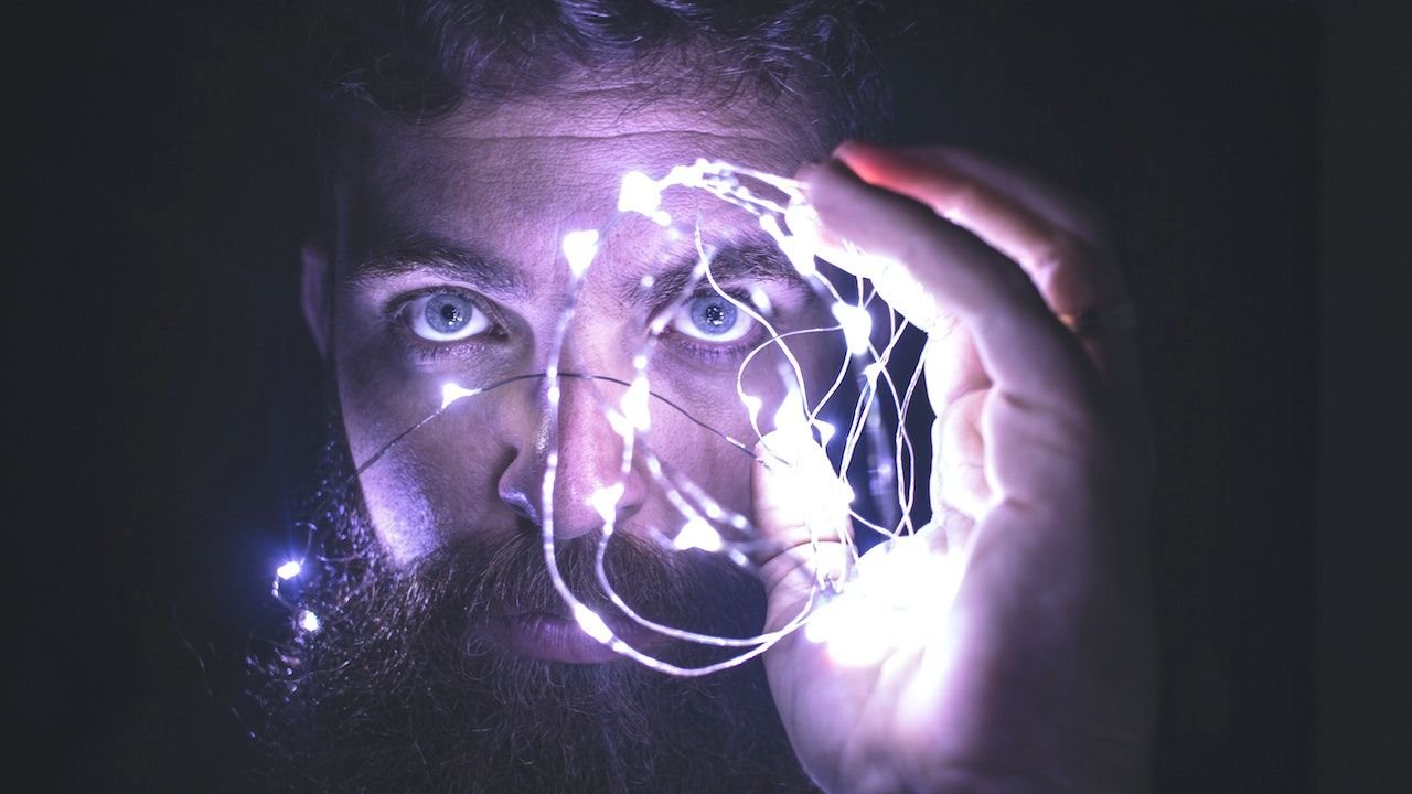 Man holding lights in front of face