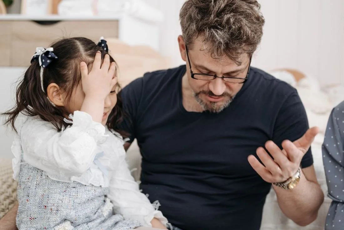 A father and daughter sitting next to each other interacting about something