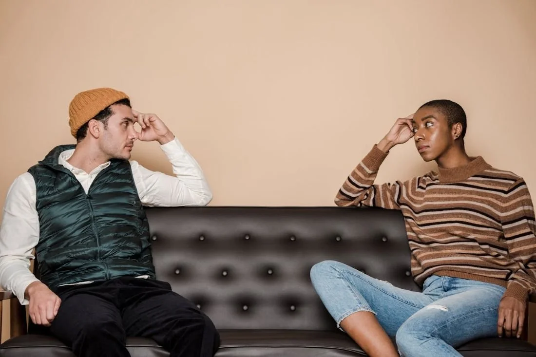 a couple sitting on a futon looking at each other
