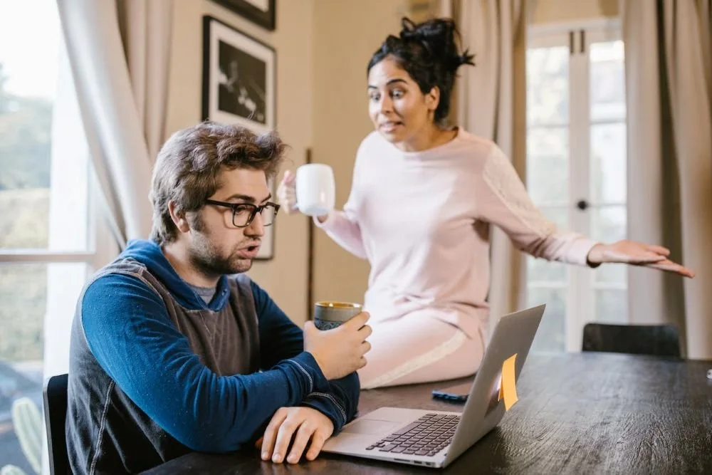 Man at computer with woman standing beside him