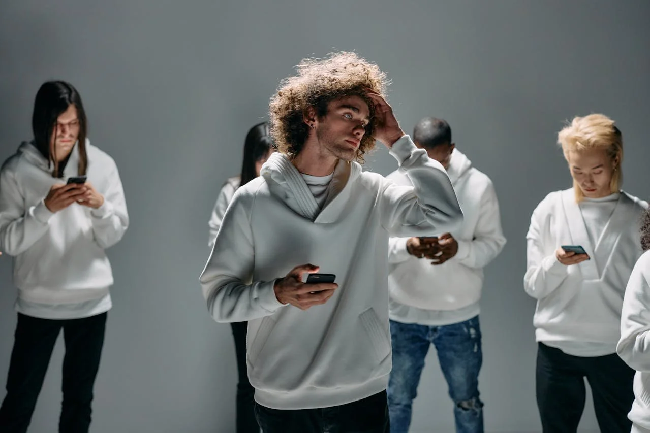 Group of diverse adults using smartphones, isolated by technology in studio setting.