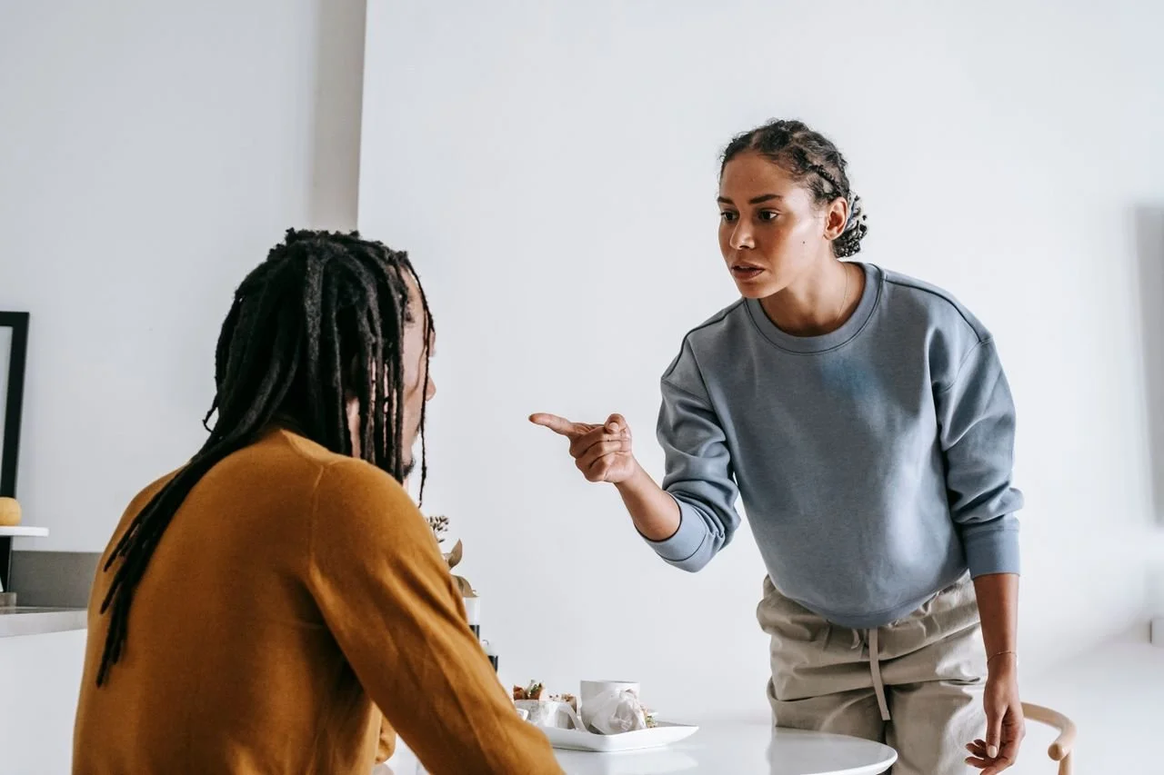 A serious conversation unfolds between a couple in a stylish kitchen setting.