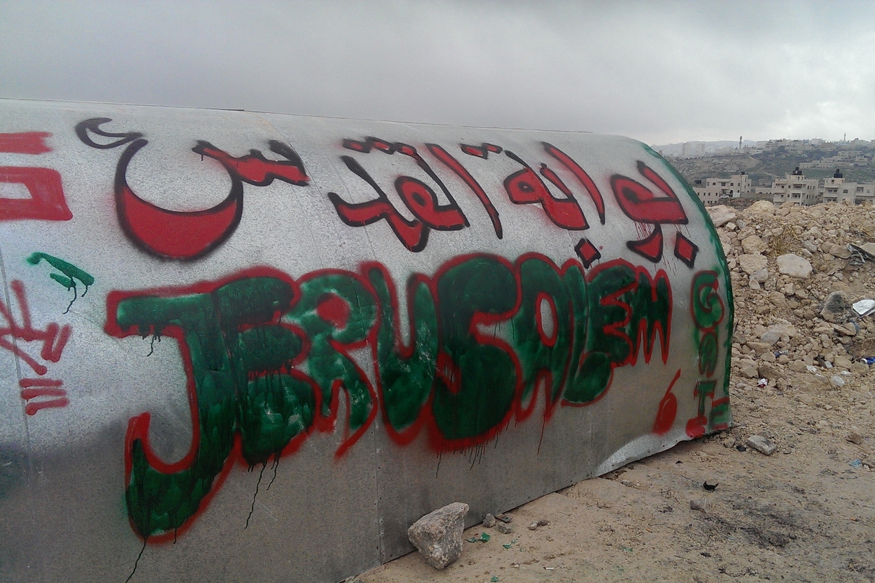 A tin shack with 'Bawabet al-Quds' spray-painted on it