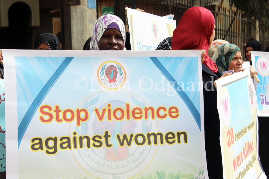 Gazan woman holds sign against femicide