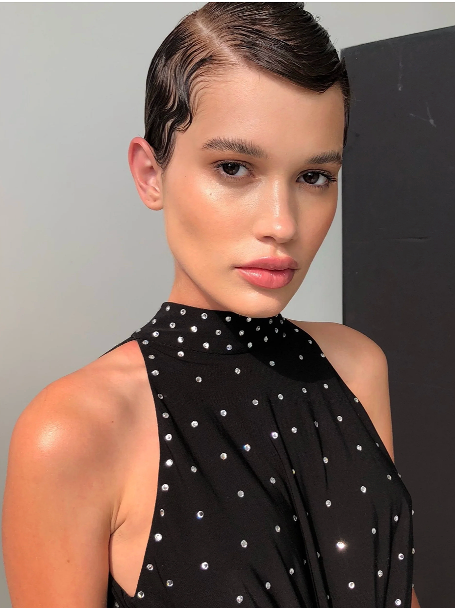 Polished hair styling and subtle makeup for high-fashion photoshoot.