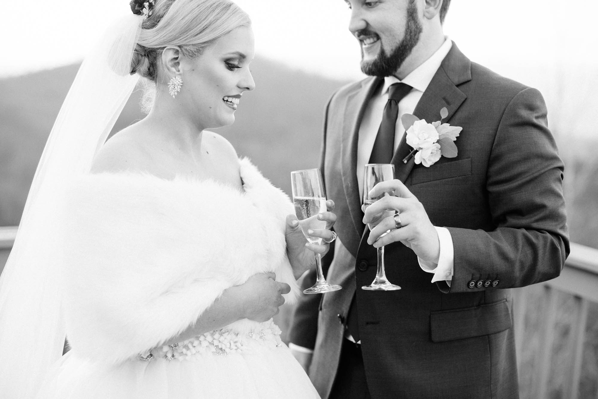 bride and groom black and white drinking champagne
