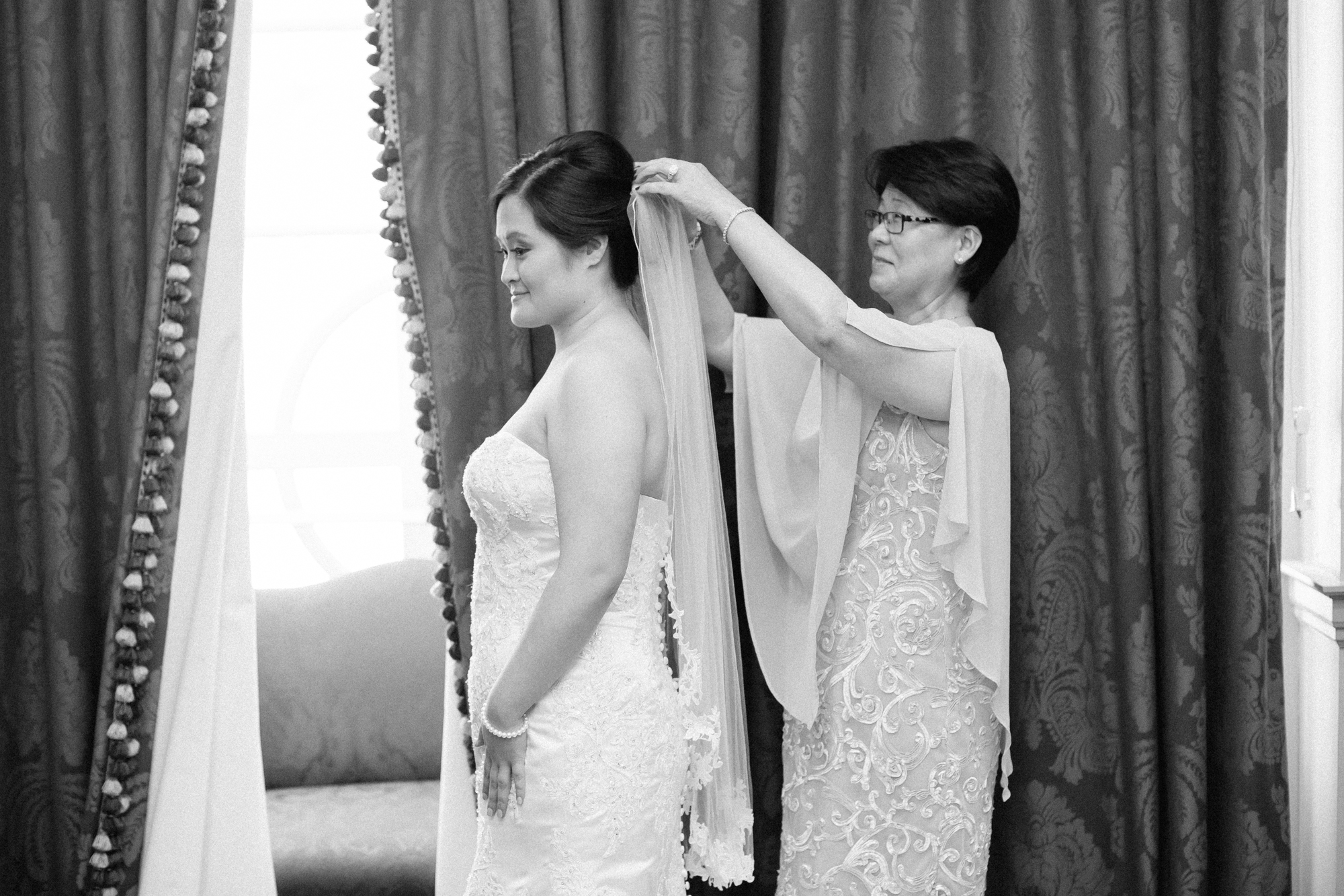 mom puts veil on bride
