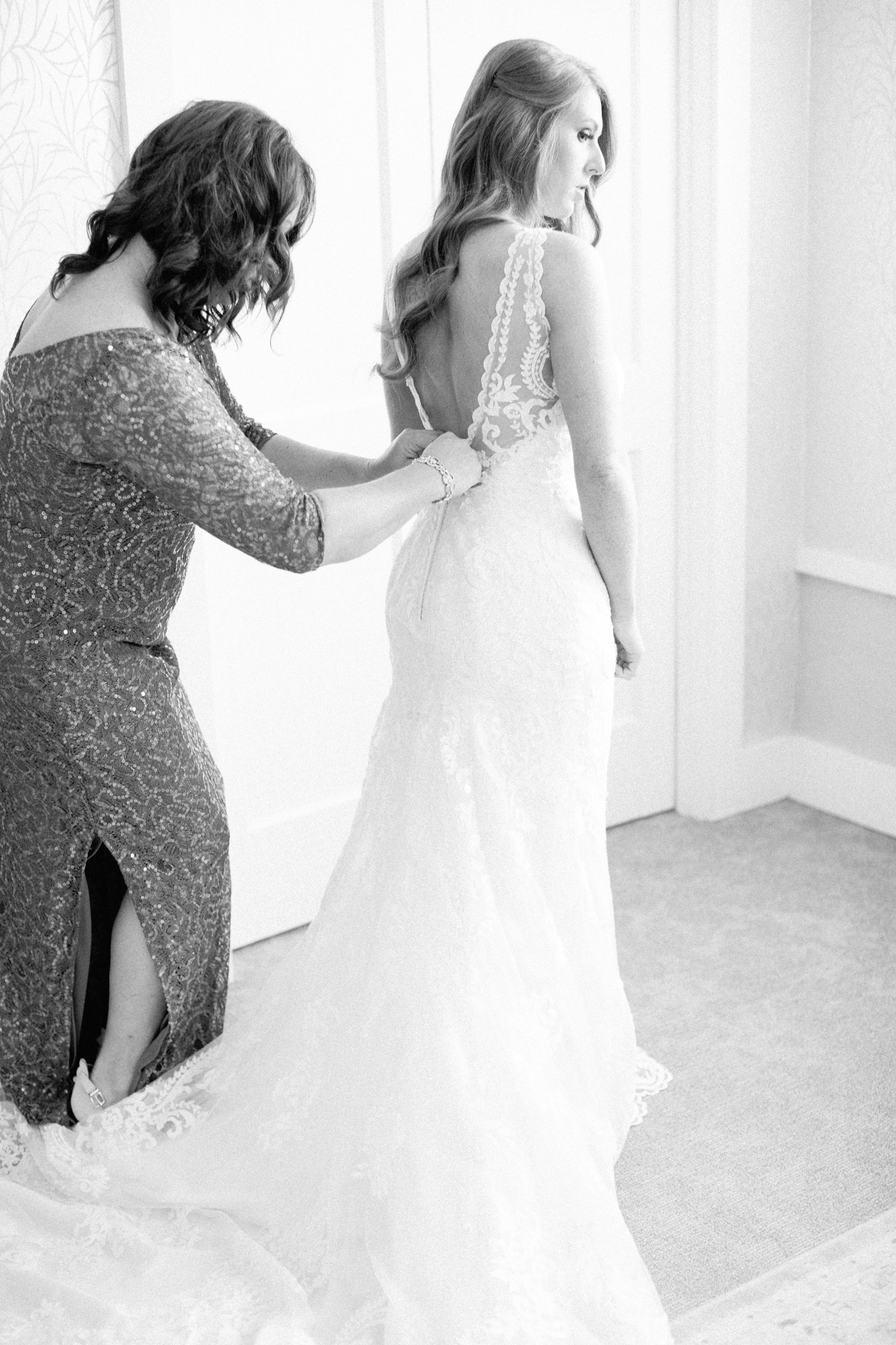 mom helps bride into dress