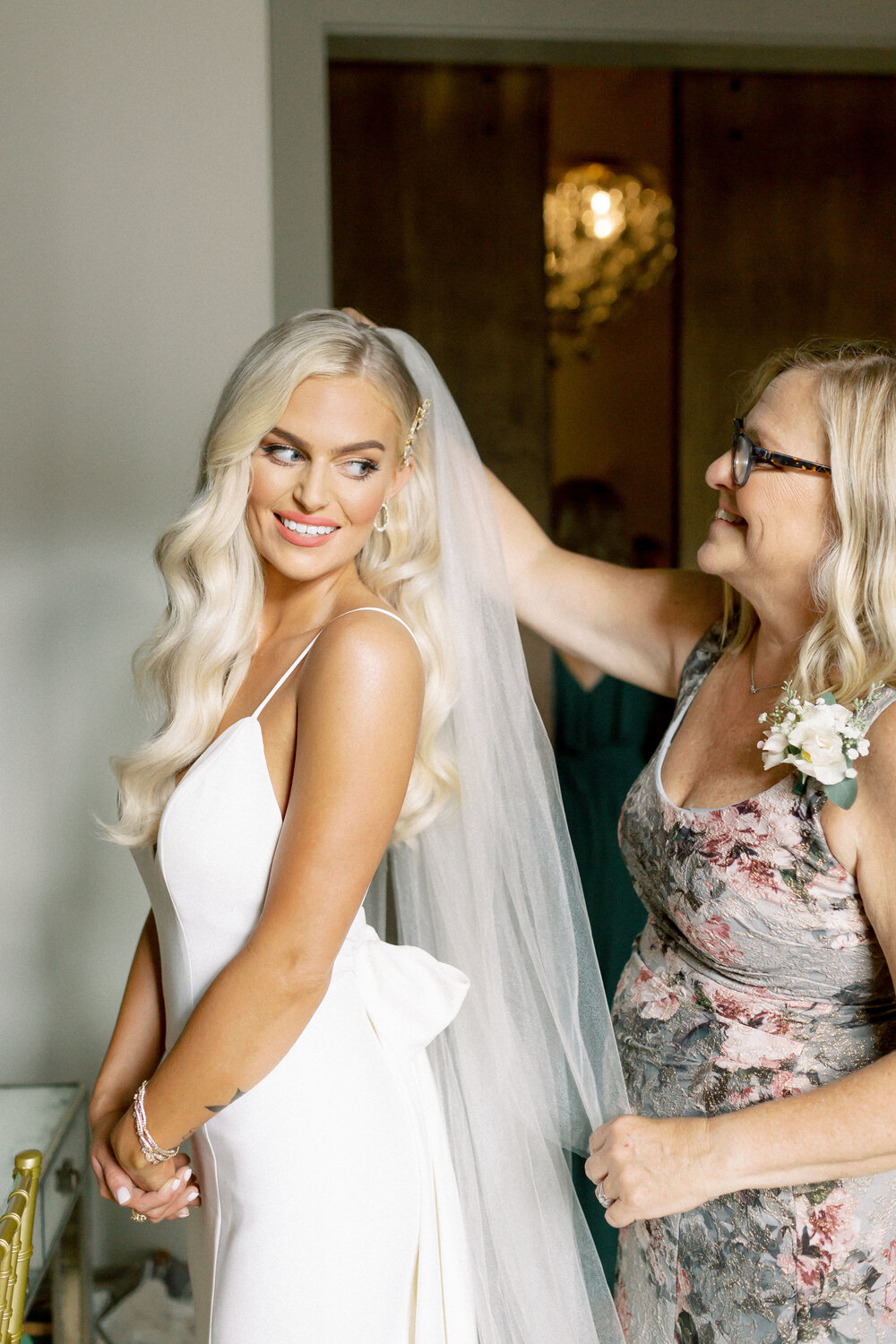 Mother helping bride with veil