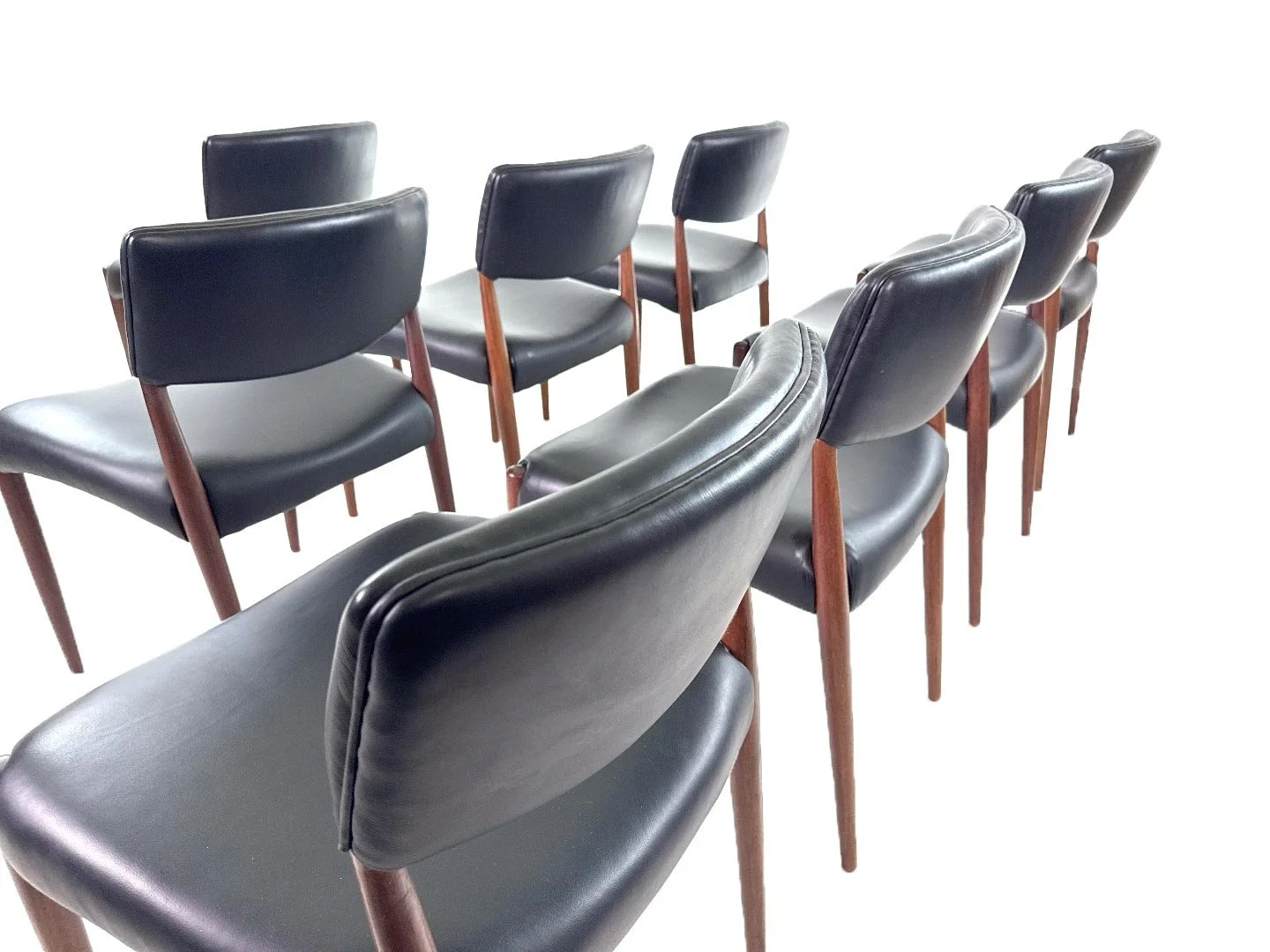 Set van 8 Deense teak stoelen van Aksel Bender Madsen & Ejnar Larsen in teak – close‑up achterkant rugleuning met leerdetail.