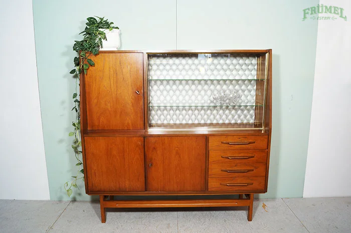 Houten kast met glazen deuren en vier laden, met een plant op de linkerbovenhoek.