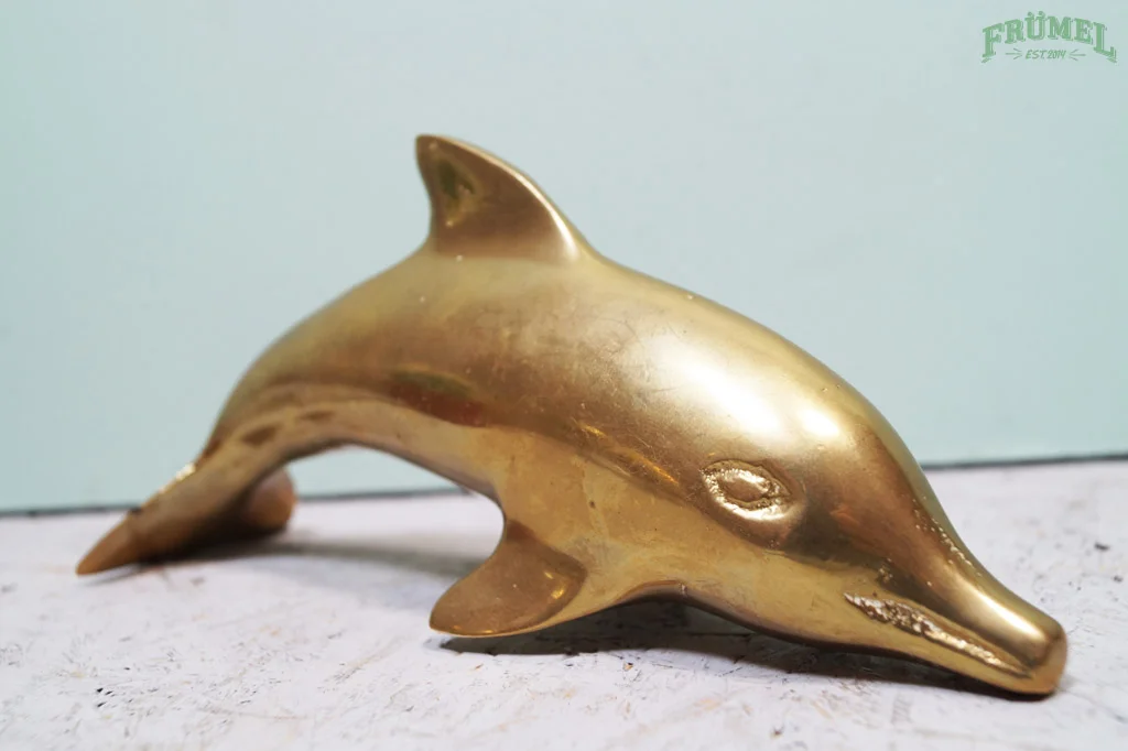Gouden Delften beeldje in de vorm van een dolfijn.