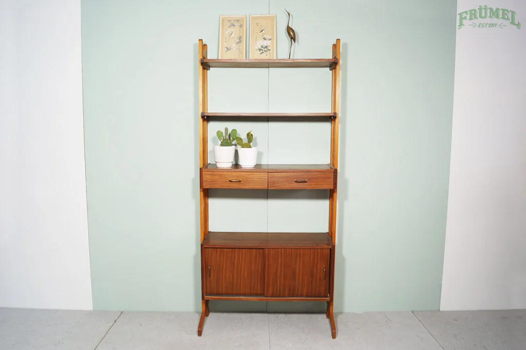 Een houten rek met drie planken, twee witte potten met cactussen op de tweede plank, en twee ingefaste lade en een schuifkast onderaan, staand op een grijze vloer tegen een groene muur.