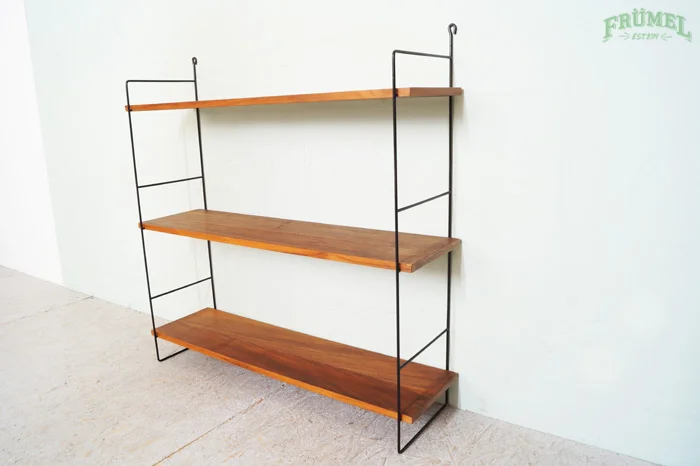 Een uitschuifbare metalen en houten wandplank in een minimalistisch interieur.