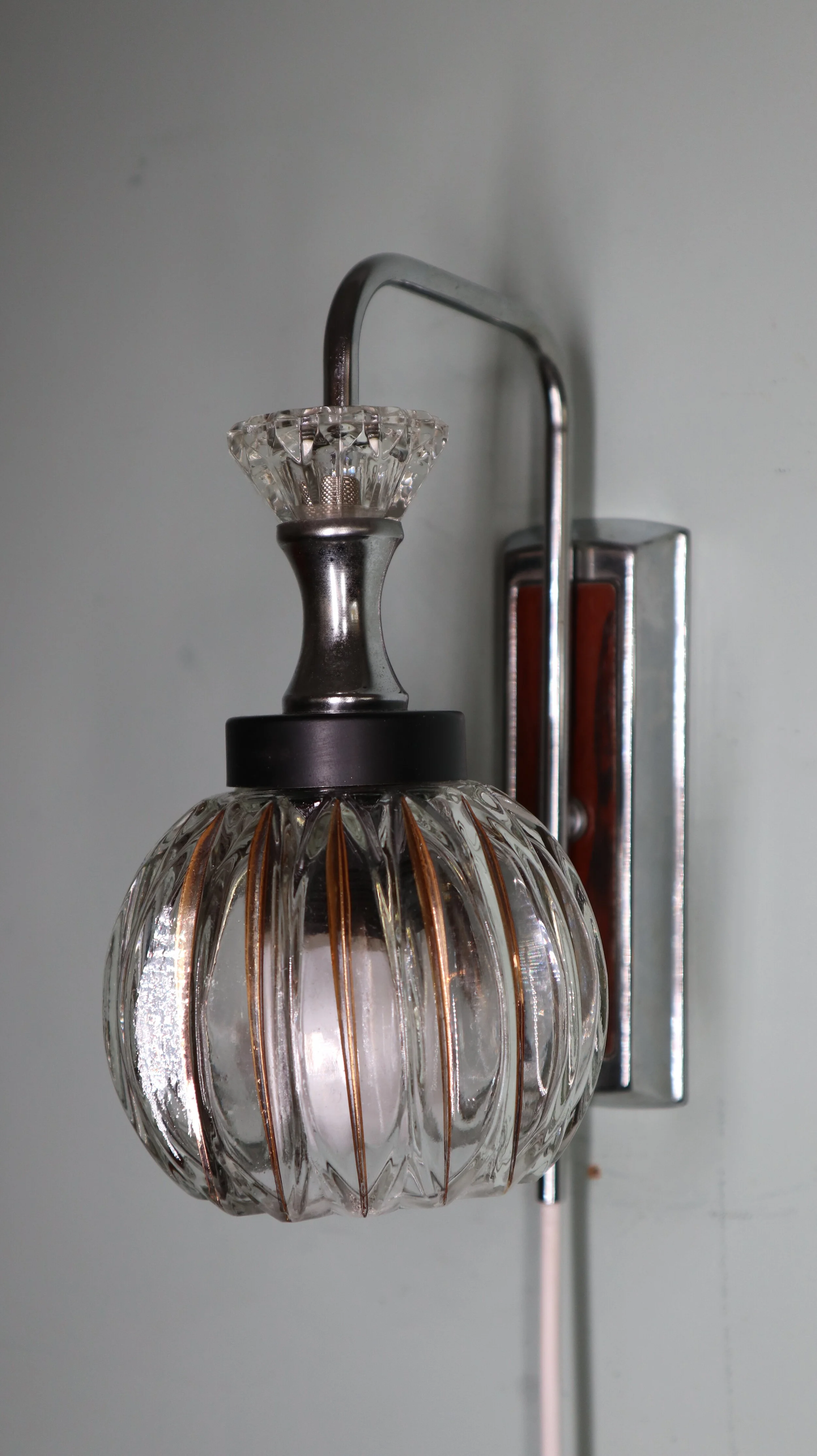 Een wandlamp met glazen loupe en metalen bevestiging
