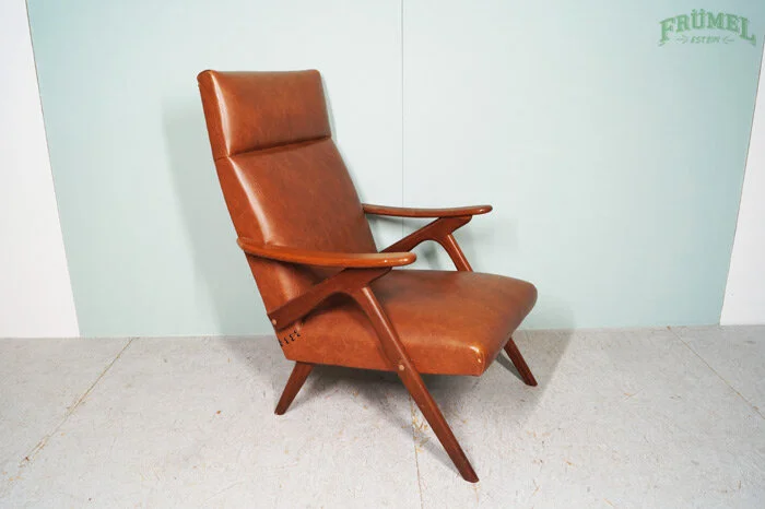 Vintage loungebank of leunstoel met houten frame en oranje bruin lederen bekleding.