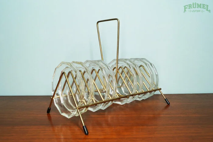Glazen bekers op een dienblad met een gouden handvat op een houten tafel.
