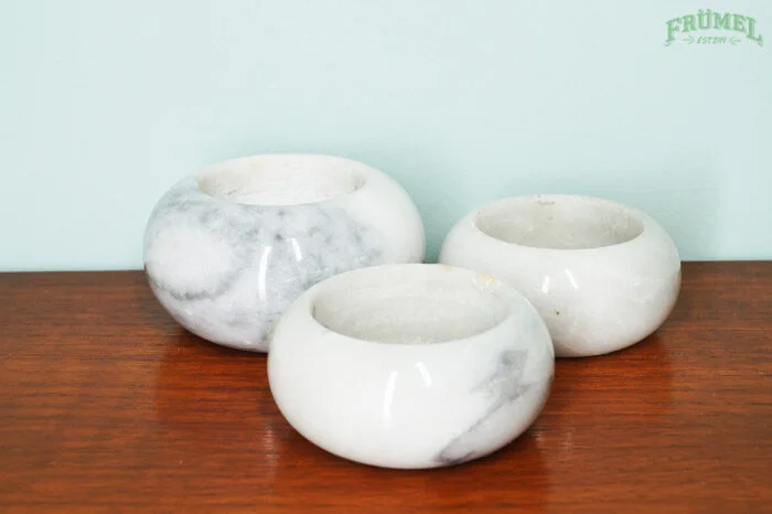 Drie witte marmeren plantenbakken op een houten tafel