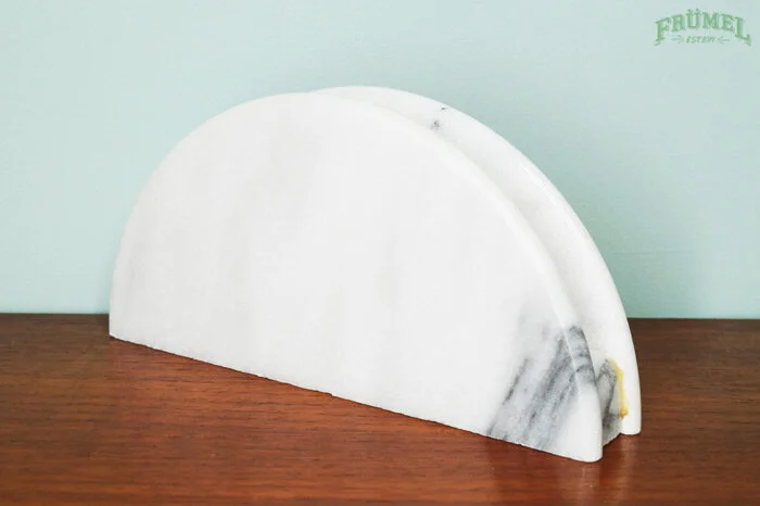 Marmeren tafelonderzetter op een houten tafel met een lichtgroene muur op de achtergrond.