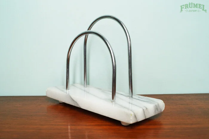 Een metalen groepering op een wit marmeren basis, geplaatst op een houten oppervlak.