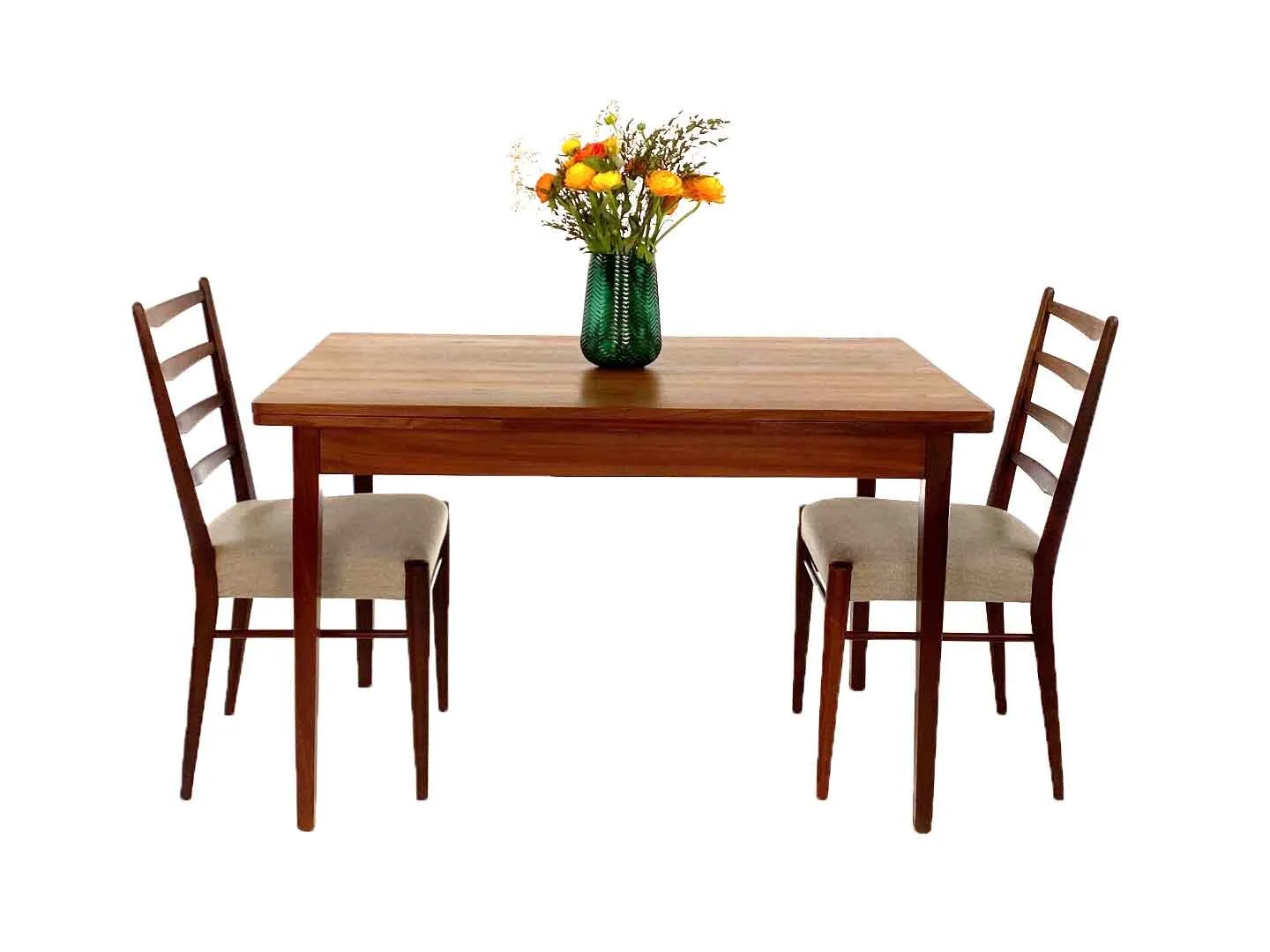Eettafel met twee houten stoelen en een groene vaas met bloemen.