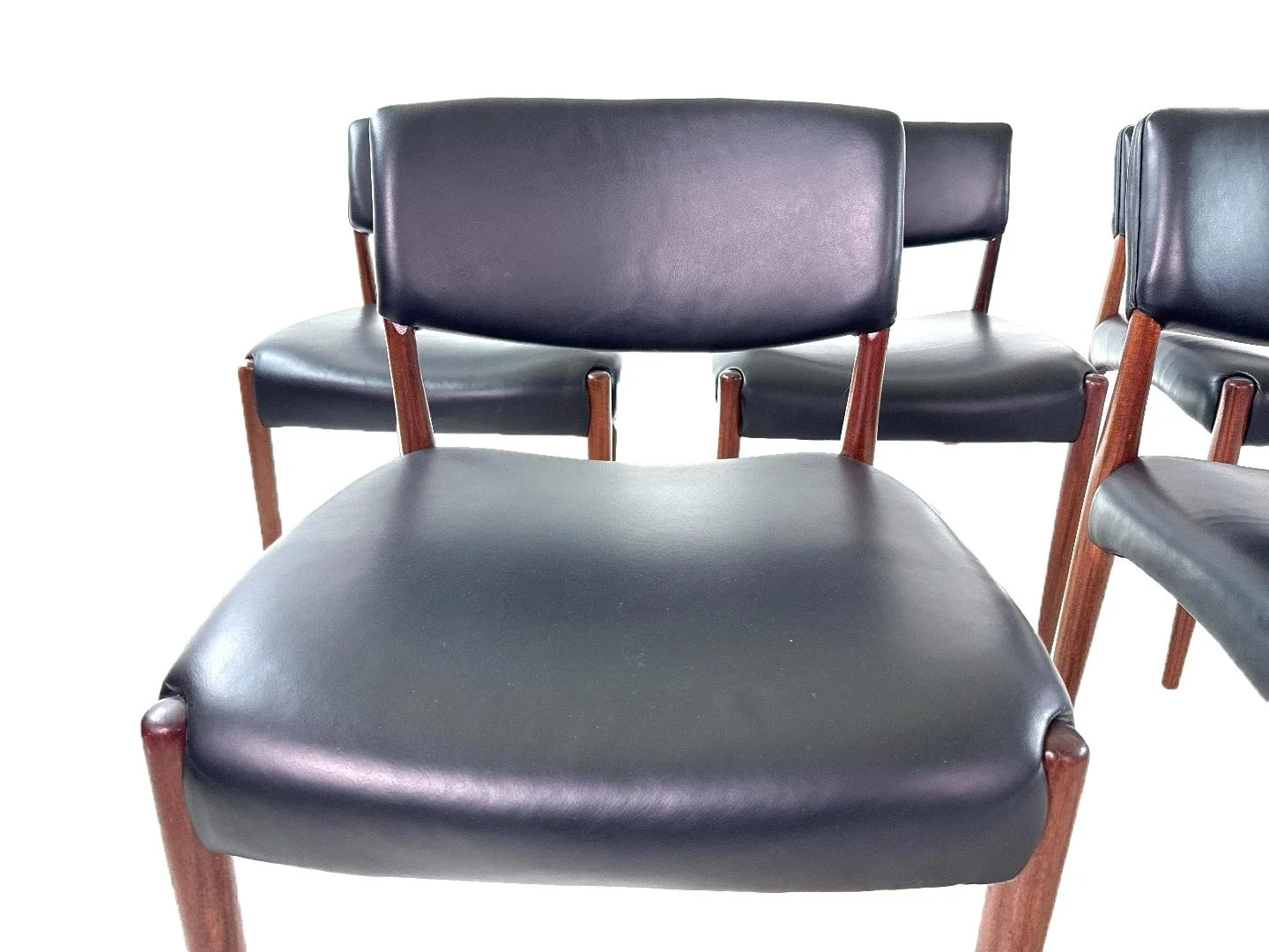 Set van 8 Deense teak stoelen van Aksel Bender Madsen & Ejnar Larsen in teak – close-up zitvlak en rugleuning en houten frame.