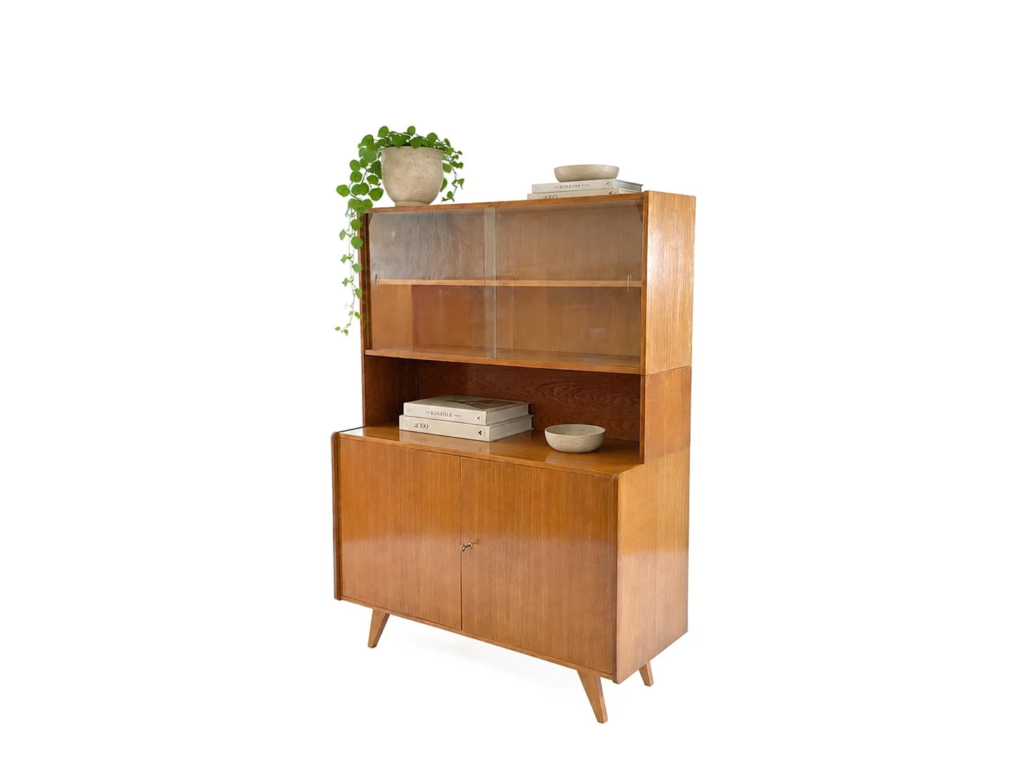 Vintage U-450 vitrinekast van Jiroutek voor Interier Praha in hout – schuin aanzicht rechtsvoor met kamerplant, keramische schalen en boeken