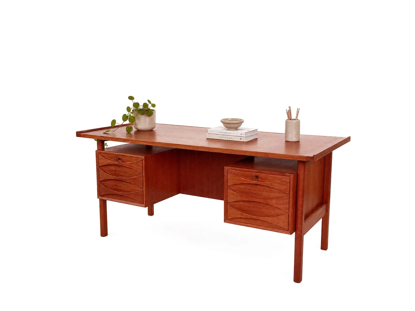 Vintage bureau model 75 van Niels Clausen in teak – schuin zijaanzicht rechts met kamerplant, keramische schaal, beker met schrijfpennen en boeken