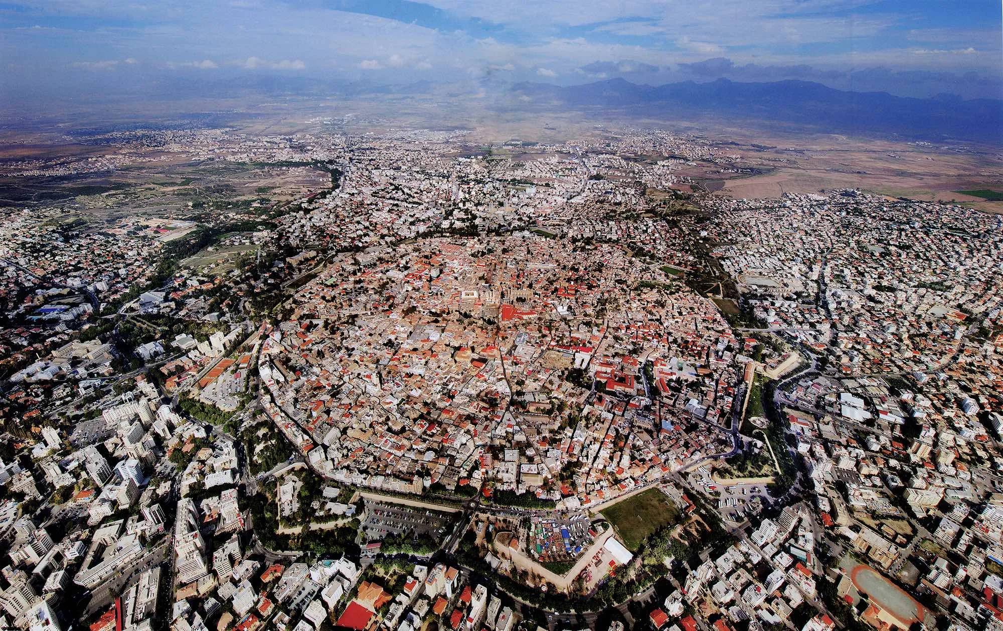 Nicosia inside and outside the Venetian walls. The city of Nicosia was contained within these walls until the first opening was made through one of its main gates in 1879. Following rapid urbanization and social change after Cypriot independence in 1960, the city spread into a continuously expanding built-up zone. Source: Yiannis Yiannelos, Archive of Militos Publications, 2017