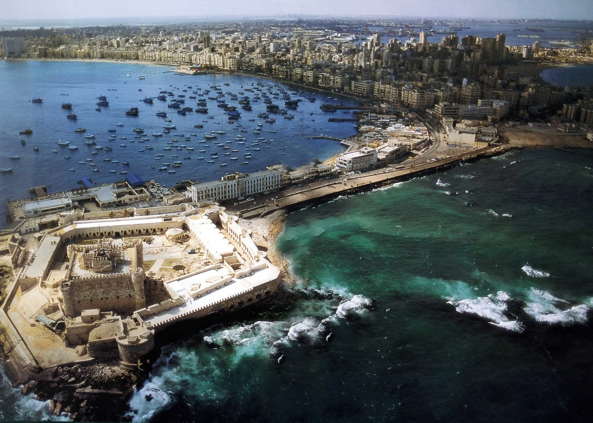 Seafront of Alexandria, facing the Eastern Harbor with its 15th century Fortress of Qaitbey, built on the site of the legendary Pharos - Alexandria’s ancient lighthouse - one of the seven wonders of the ancient world. Visible is the West Harbor which handles most of Egypt’s commercial shipping and foreign trade. Source: AlexMED, Bibliotheca Alexandrina.