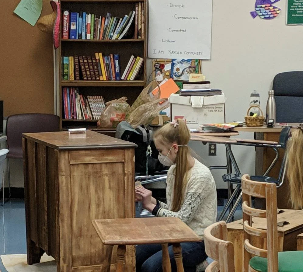 A WinterMission participant refinishes furniture for a local refugee family. (Photo courtesy of Nardin Academy)