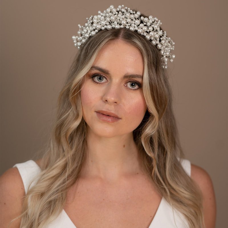 A bold statement tiara with shimmering pearls fanning out on multiple branches of delicate and flexible wire to create a grand tiara with a dense covering of different sized pearls by Arianna Tiaras.