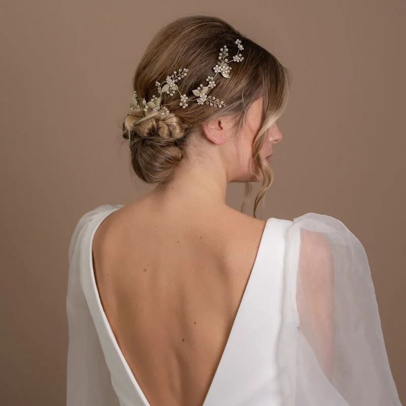 A delicate bridal hair vine with pretty flower and leaf detailing created using shimmering crystals and pearls by Arianna Tiaras.