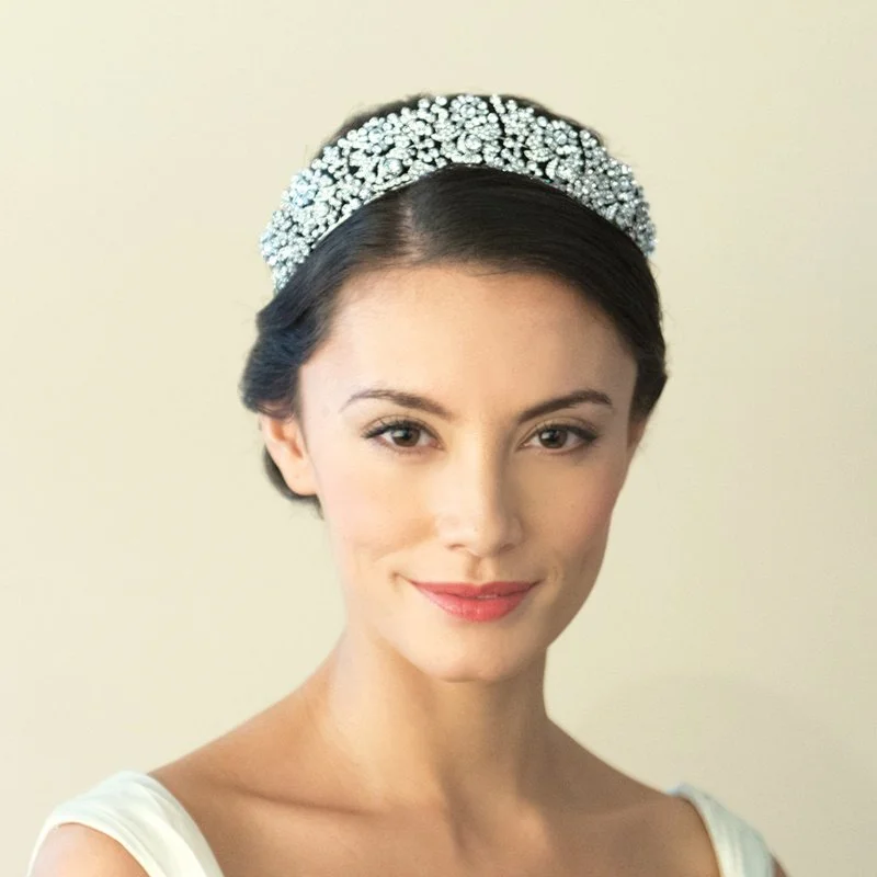 Queen Anne is a stately tiara for a truly spectacular effect. Created using an array of dazzling stones in cut solitaires and baguettes, forming intertwined flowers and leaves by Ivory & Co.