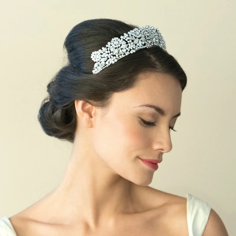 Queen Anne is a stately tiara for a truly spectacular effect. Created using an array of dazzling stones in cut solitaires and baguettes, forming intertwined flowers and leaves by Ivory & Co.