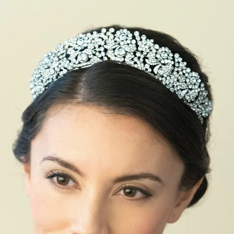 Queen Anne is a stately tiara for a truly spectacular effect. Created using an array of dazzling stones in cut solitaires and baguettes, forming intertwined flowers and leaves by Ivory & Co.
