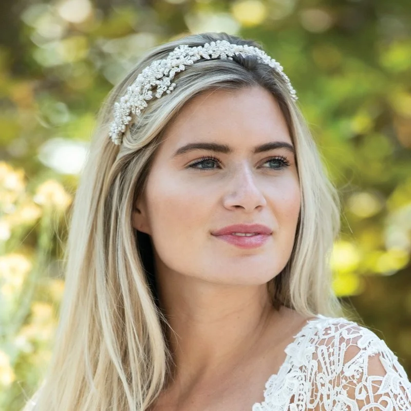 Blanche is a very delicate pretty headpiece made up of sparkling solitaire cut stones set in a pattern of blossom leaves and intertwined with vines of small ivory pearls by Ivory & Co.