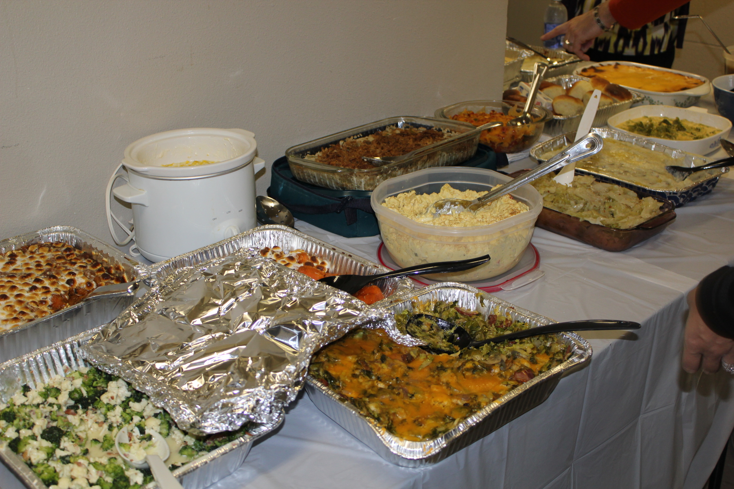Classic potluck spread consisting of casseroles in aluminum. Casseroles in corningware. Casseroles in pyrex. (duplicate candied sweet potato casserole... so embarrassing). Note the mashed potatoes with the lid underneath the bowl AS IF there will be any left over to pack up and take home. Everyone hates whoever brought the broccoli and cauliflower "salad" and the crock pot is a sign of professionalism... this ain't their first potluck.