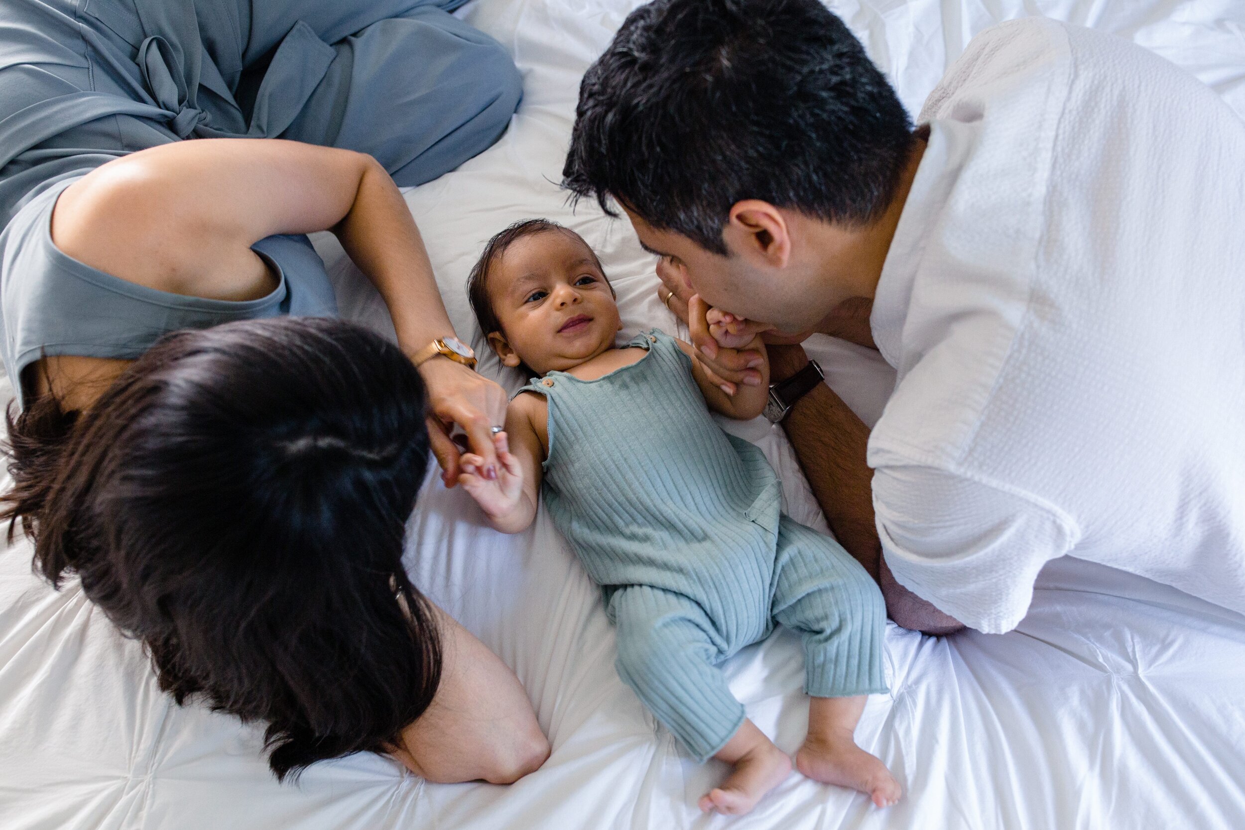 baby-with-parents-on-bed-overhead-photo.jpg