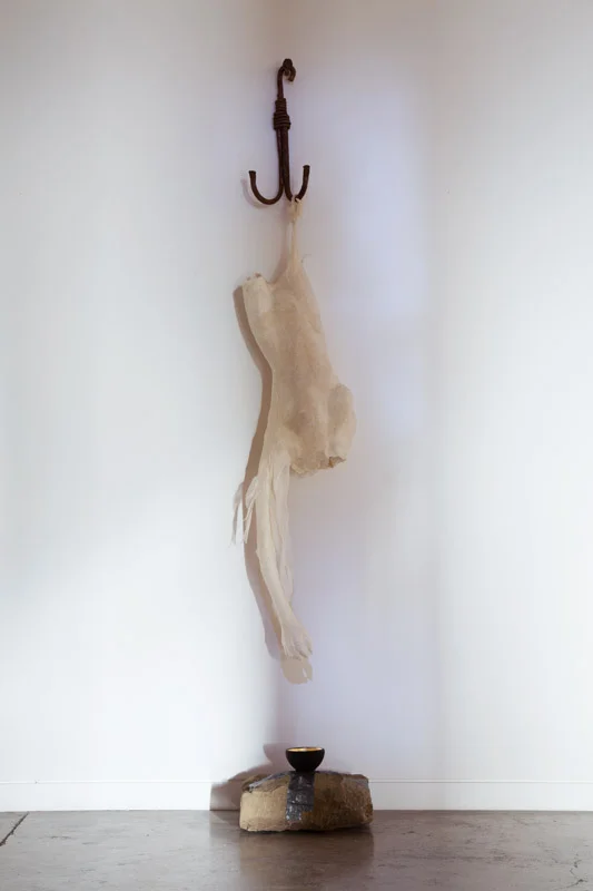 Inanna is Hung from a Hook, 2014, forged metal hook, moulded enacaustic silk paper and tarlatan, sandstone rock, beaten lead and ceramic bowl with gold leaf.