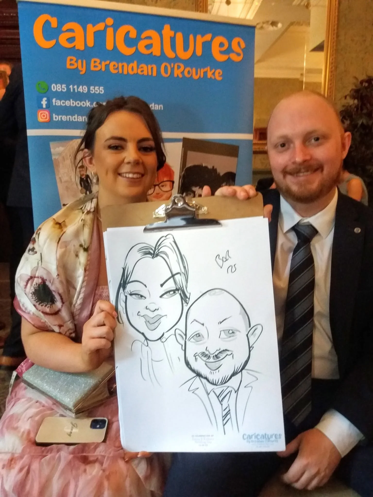 Couple with a personalised caricature drawn during an Irish wedding drinks reception.