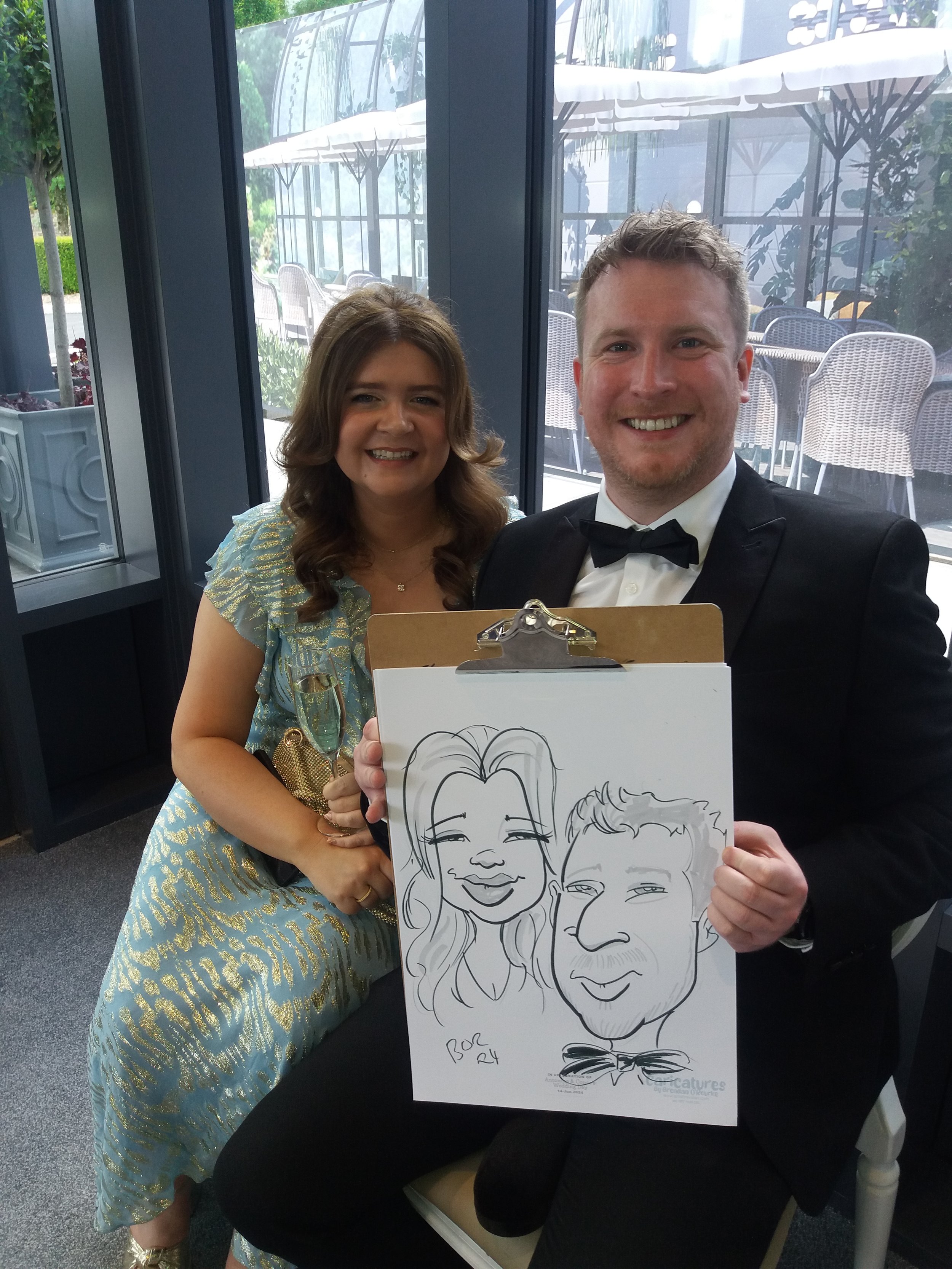 A couple showing their personalised caricature drawn live during the evening.