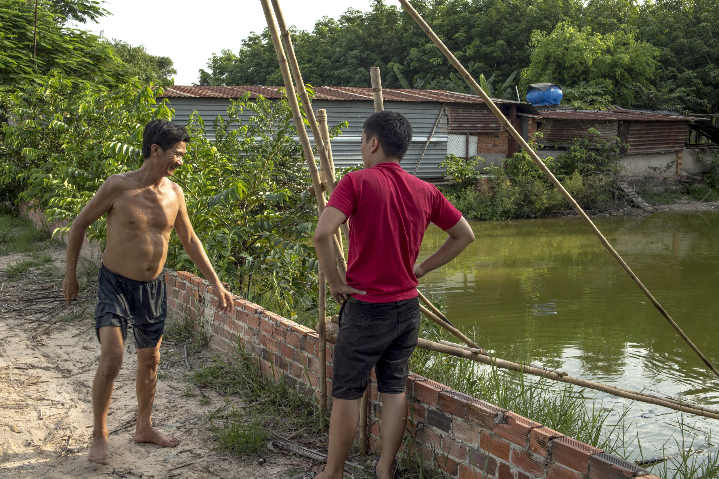 Host & teacher, Sơn, testing the vó bè. The party shack in the background. Nephew (Phức Nguyên) in the foreground.